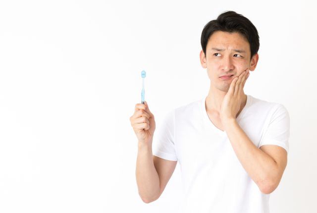歯に痛みを感じている男性